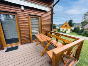 a wooden deck with a bench and a house at TEVA Lipno 131 in Lipno nad Vltavou