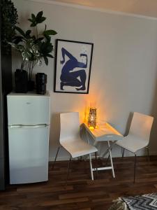 een kamer met 2 stoelen en een tafel met een lamp bij Super central studio apartment in Tromsø