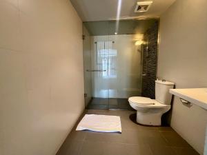 a bathroom with a toilet and a glass shower at Candea Cocoon Kandy in Kandy