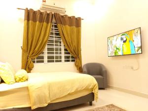 a bedroom with a bed and a window and a chair at Homestay VillaSolihin Sungai Buloh in Sungai Buluh +29 photos