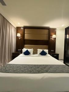 a bedroom with a large white bed with blue pillows at Ebreez Hotel in Jeddah +26 photos