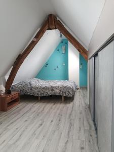ein Schlafzimmer mit einem Bett auf einem Dachboden in der Unterkunft Le chant des grenouilles in Boismont