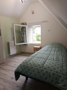 ein Schlafzimmer mit einem Bett und einem Fenster in der Unterkunft Le chant des grenouilles in Boismont + 7 Fotos