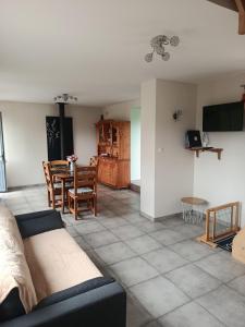 ein Wohnzimmer mit Sofa und Tisch in der Unterkunft Le chant des grenouilles in Boismont