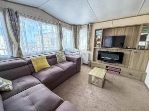 a living room with a couch and a flat screen tv at Lovely Caravan At Azure Seas Nearby The Beautiful Beach Ref 32038Az in Lowestoft