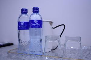 two bottles of water on a tray with two glasses at SARROJ Boutique in Bukhara