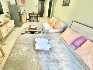 a living room with a large bed and a couch at Condo Unit inside IT Park Lahug Cebu City in Cebu City