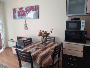 a dining room table with a vase of flowers on it at Elza Apartment in Pamporovo