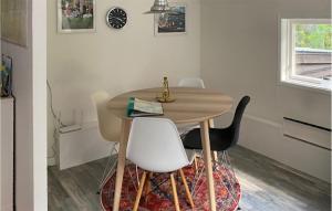 a dining room with a wooden table and white chairs at Gorgeous Home In Ljusterö in Norra Ljustero