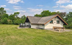 a house with a picnic table and a bench at Holiday Home Drejet Rudkøbing Xi in Spodsbjerg