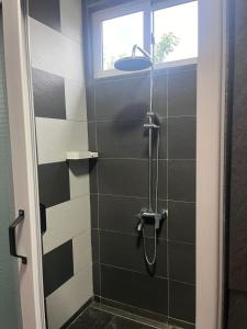 a bathroom with a shower with black and white tiles at Blue IV residence in Mauritius