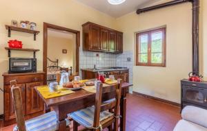 a kitchen with a wooden table with chairs and a stove at Pet Friendly Apartment in Monte Santa Maria Tiberina