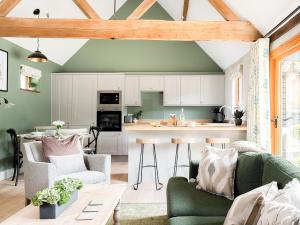 a kitchen with white cabinets and a green ceiling at Lantern Lodge in Bramley