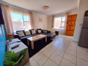 a living room with a couch and a table at MV self-catering 3 Units in Bloemfontein
