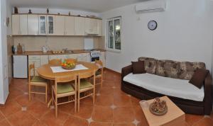 eine Küche und ein Wohnzimmer mit einem Tisch und einem Sofa in der Unterkunft Apartments Miana in Tivat