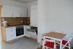 a kitchen with white cabinets and a table and chairs at 1A Ferienwohnung Bamberg in Bamberg +8 photos