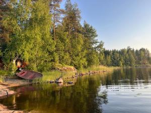 una barca sulla riva di un fiume di Villa Laura a Savonlinna