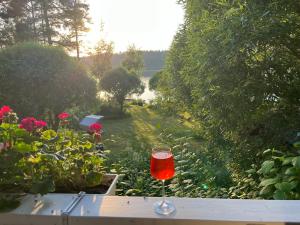 un bicchiere di vino appoggiato su un tavolo accanto ai fiori di Villa Laura a Savonlinna