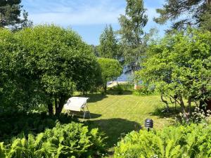un giardino con una panchina bianca all'ombra degli alberi di Villa Laura a Savonlinna 1 altra foto