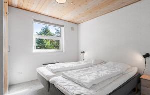 une chambre blanche avec deux lits et une fenêtre dans l'établissement Holiday Home Søren Gades Mark Blåvand Denm, à Blåvand