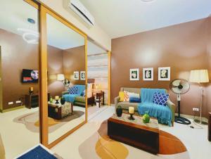 un soggiorno con un divano blu e uno specchio di LUX BGC 1BR, Uptown Mall Connector, 5G WiFi, Pool, Ste 11 a Manila Altre 18 foto
