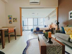 un ampio soggiorno con un letto e un divano di LUX BGC 1BR, Uptown Mall Connector, 5G WiFi, Pool, Ste 11 a Manila