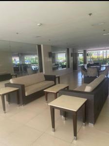 a living room with couches and tables and windows at 1 BR Family Condo near NAIA behind SM Sucat Paranaque Manila Philippines in Manila