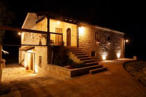 a stone building with stairs on the side at night at Agriturismo Verdebosco in Roccamorice