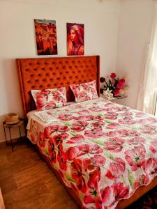 ein Schlafzimmer mit einem Bett mit einer geblümten Tagesdecke in der Unterkunft Chez Basma in Rabat