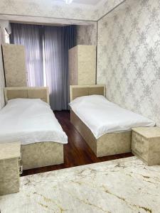 サマルカンドにあるluxury apartments 6のベッドルーム1室(ベッド2台、ラグ付) +3枚の写真