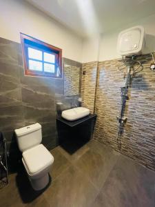a bathroom with a toilet and a sink and a window at Yala Safari Rest in Tissamaharama