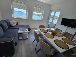 a living room with a table and a couch at VILA KIKA in Rogoznica