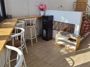 a kitchen with a counter and stools and a refrigerator at Laswi Syariah Guest House in Bandung