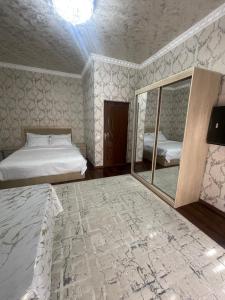 サマルカンドにあるluxury apartments 6のベッド2台と鏡のある寝室