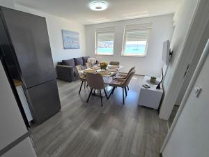 a dining room and living room with a table and chairs at VILA KIKA in Rogoznica