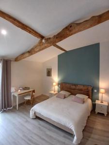 a bedroom with a large white bed and a desk at Les chambres du Couraud in Saint-Aubin-des-Ormeaux
