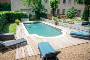 a swimming pool with two chairs and a table at La Grande Maison Mazamet in Mazamet