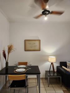a dining room with a table and a ceiling fan at Apto 337 - AgrishowShoppingFATESA in Ribeirão Preto