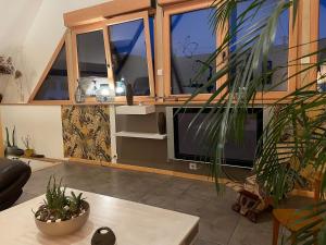 a living room with a large window and a table at Au moulin maison familiale in La Broque