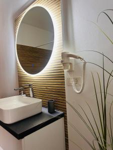 a bathroom with a sink and a mirror at Neva Apartments & Rooms in Făgăraş +41 photos