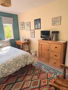 a bedroom with a bed and a tv on a dresser at B&B Higher Quantock in Stockland