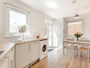 a kitchen with a sink and a washing machine at Dove Cottage in Inverness