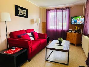 YtterhogdalGamla Posten Huset的客厅里有一张红色沙发和一张桌子。