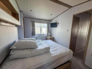 a small bedroom with a bed in the corner at Beautiful Caravan With Decking At Carlton Meres Holiday Park, Suffolk Ref 60022M in Saxmundham +16 photos
