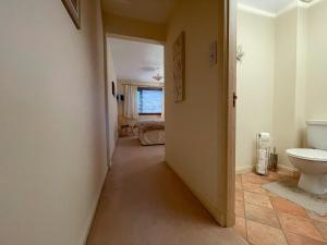 a hallway leading to a bathroom with a toilet at Bervie Road Cottage in Kinlochbervie