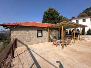 a patio with benches and a wooden pergola at Refúgio do Grilo in Castelo de Paiva +26 photos