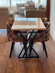 a table and chairs with a table and a couch at Centaurus Ultra Luxury 2BHK Mountain Vista Apartment in Islamabad +10 photos