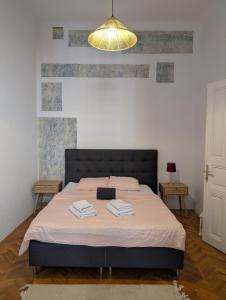 una camera da letto con un letto con due asciugamani sopra di Tiskara 1897 a Zagabria