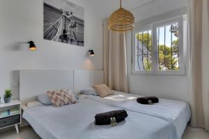 two beds in a room with two windows at Bungalow Marquérite Moraira, 5 minutes from beach in Teulada +51 photos