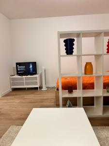 a white room with a bed and a television at Vases d'honneur HOME proche de Paris et du stade de France in Aubervilliers